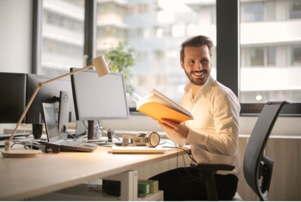 young male business owner at desk smiling