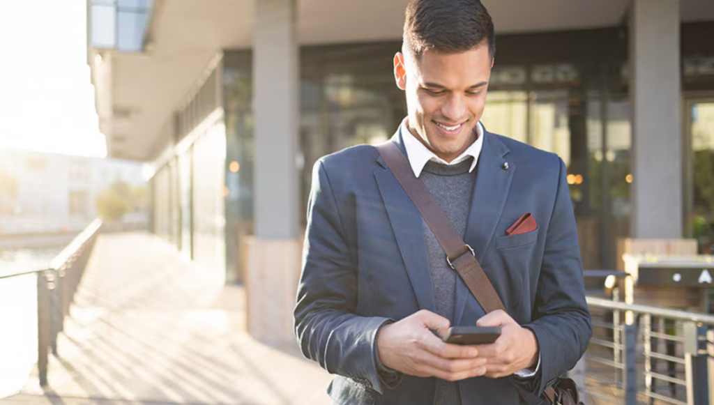 man in suite looking a cell phone in hands