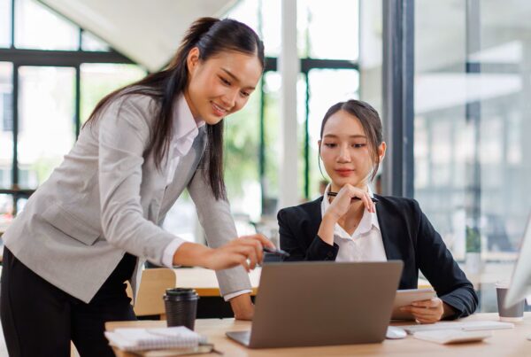 two asian women looking at computer
