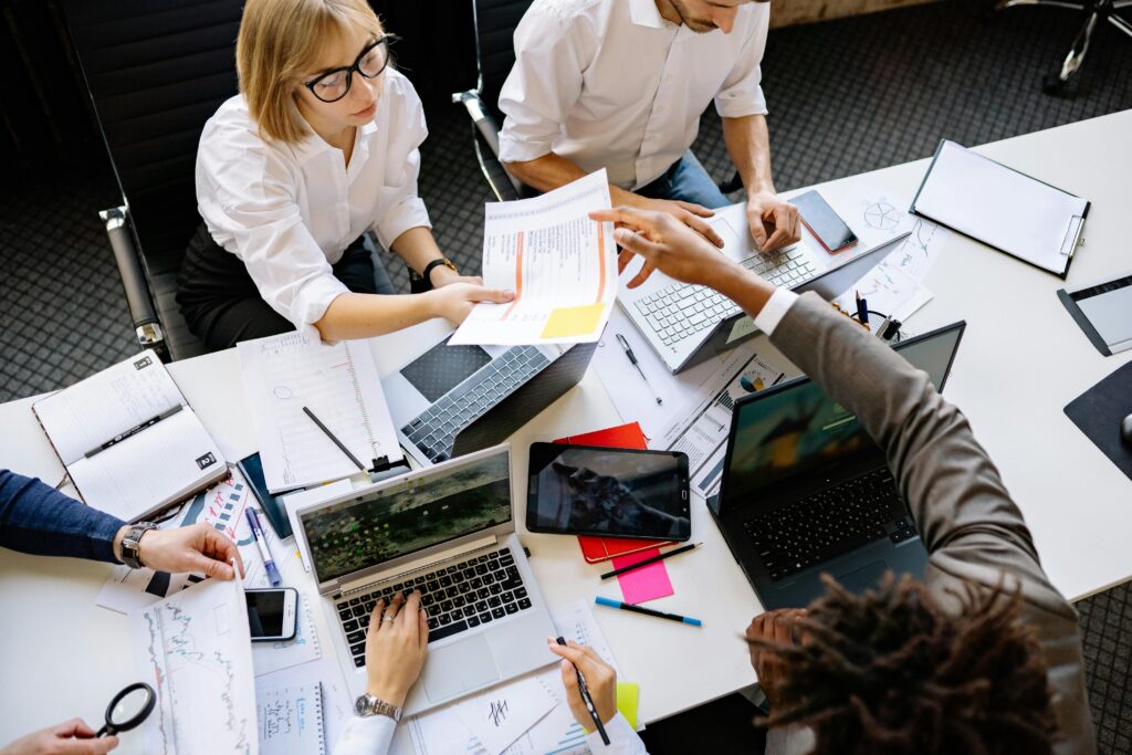 team of people sitting at table looking over reports