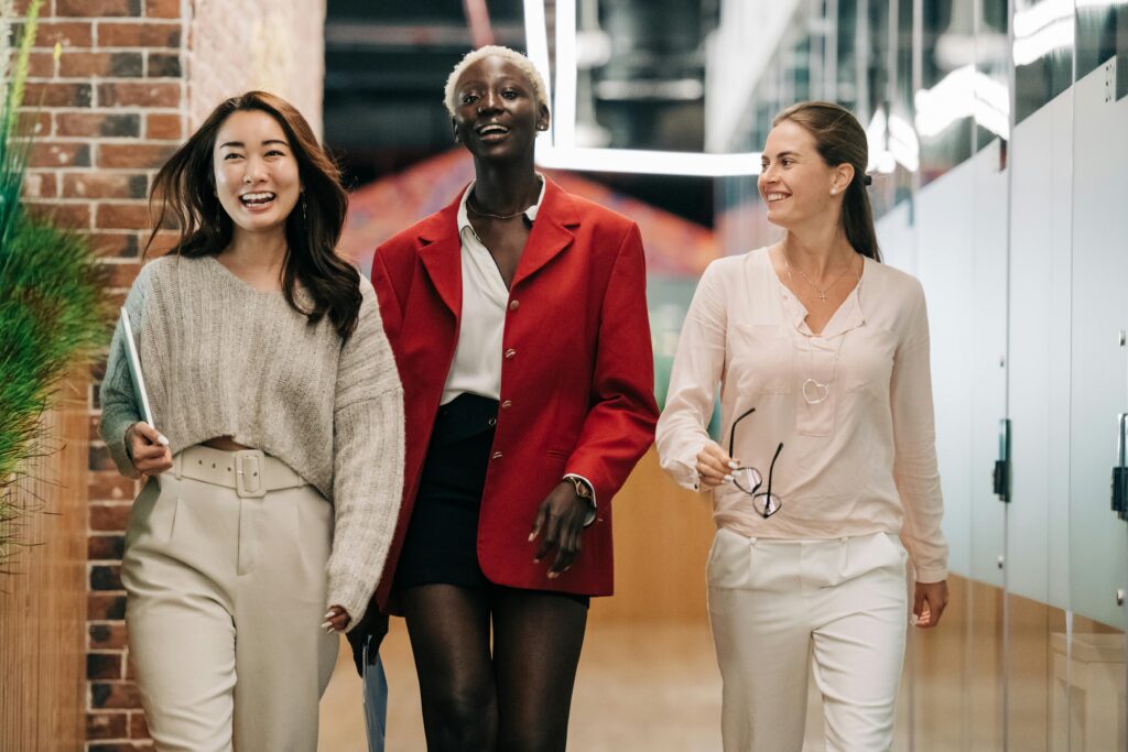 three women walking and talking in a office