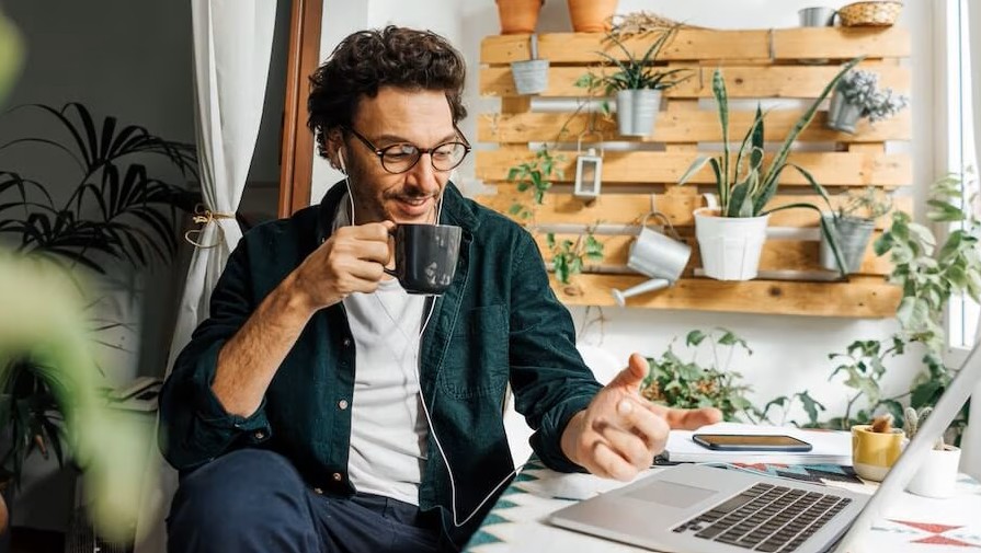 man with coffee sitting a desk