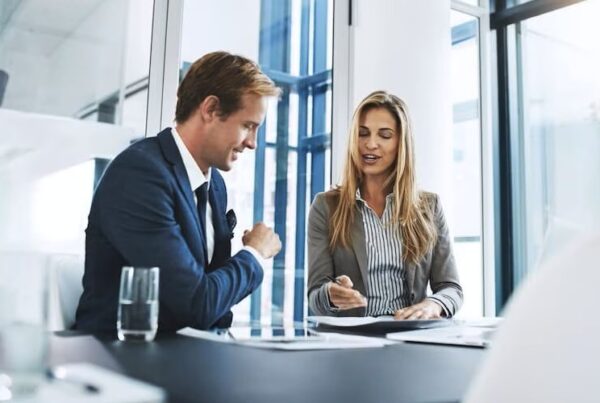 man and woman talking at desk