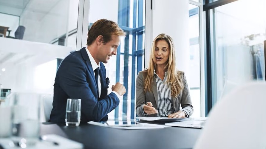 man and woman talking at desk
