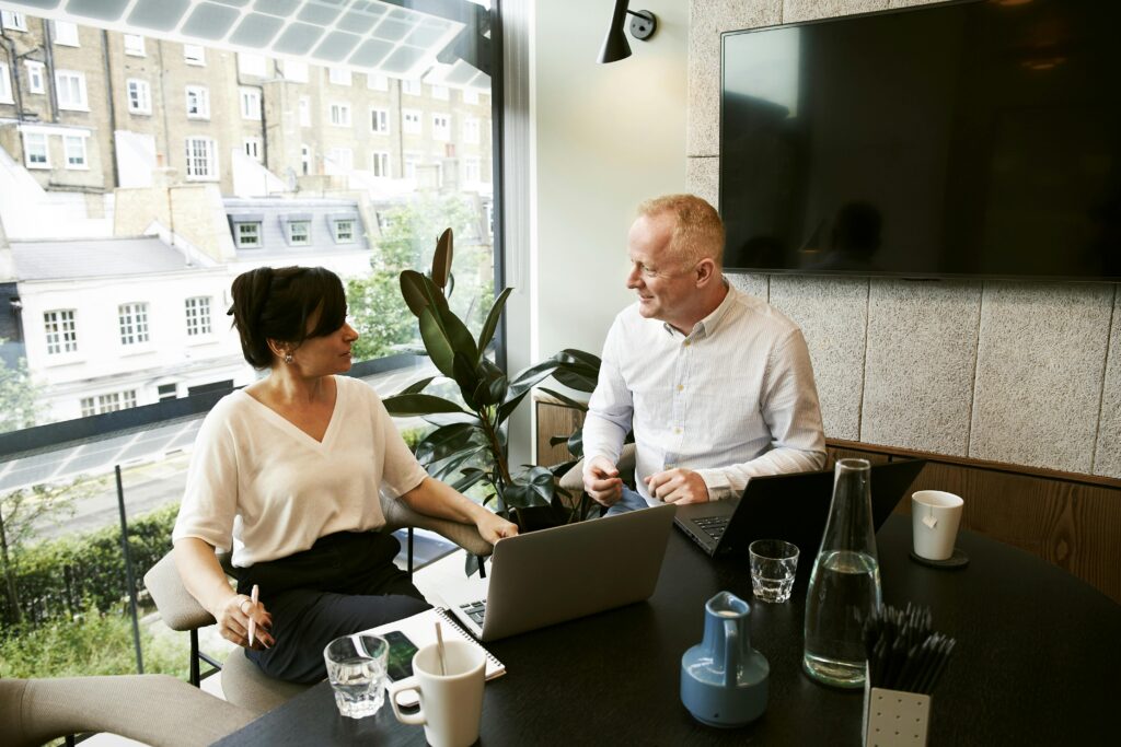 man and woman sitting in front of a window 